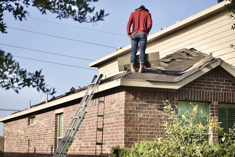 Professional roofer working on a residential roof in Braeswood Place